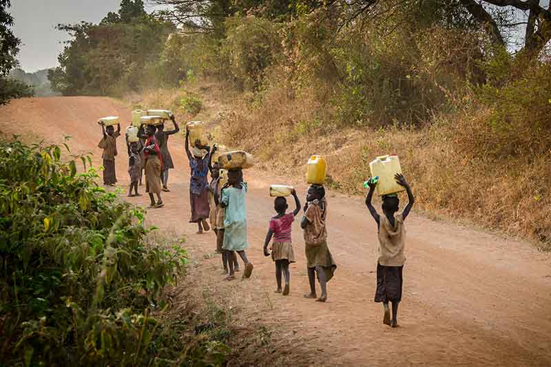 children-in-dry-land-carrying-waterbottles-on-head-colin-austin-gbiota